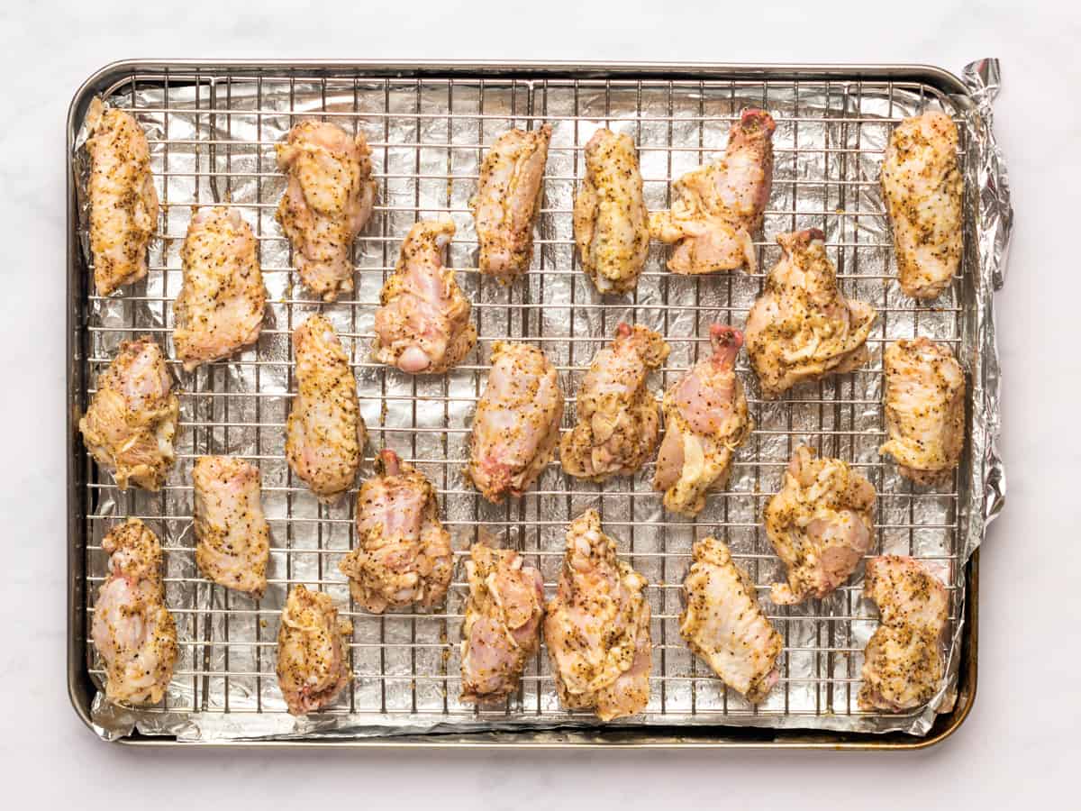 lemon pepper wings on a wire rack set in a baking sheet.