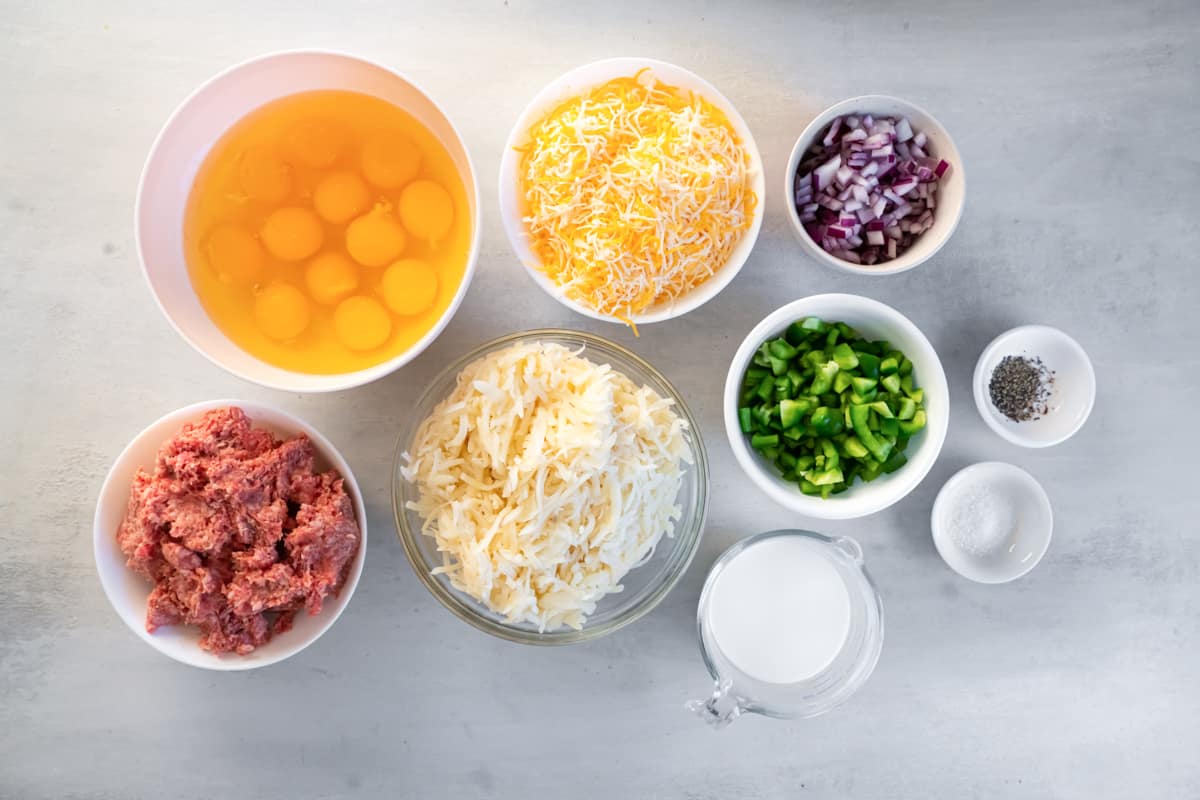 the ingredients for a hamburger are shown in bowls on a gray background.