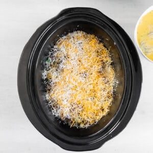 a crock pot filled with cheese and eggs.