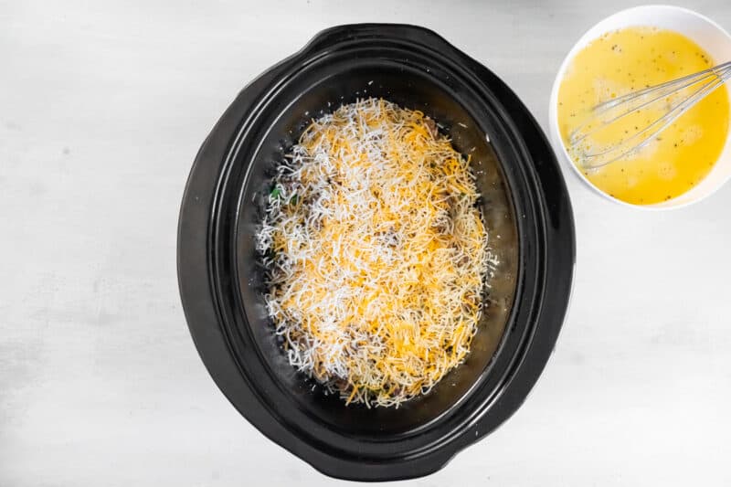 a crock pot filled with cheese and eggs.