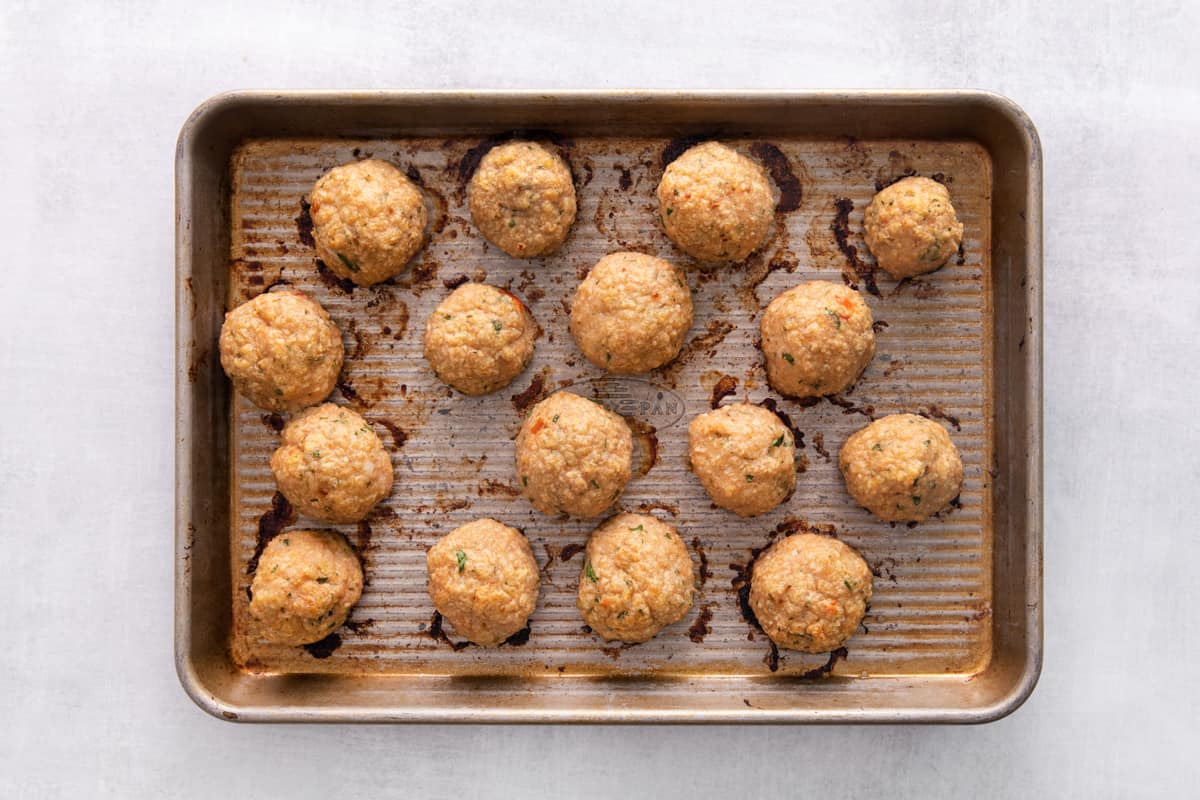 Baked Thai chicken meatballs on a baking sheet.