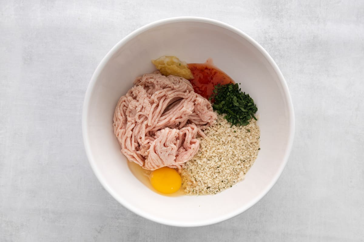 Ground chicken meatball ingredients in a mixing bowl.