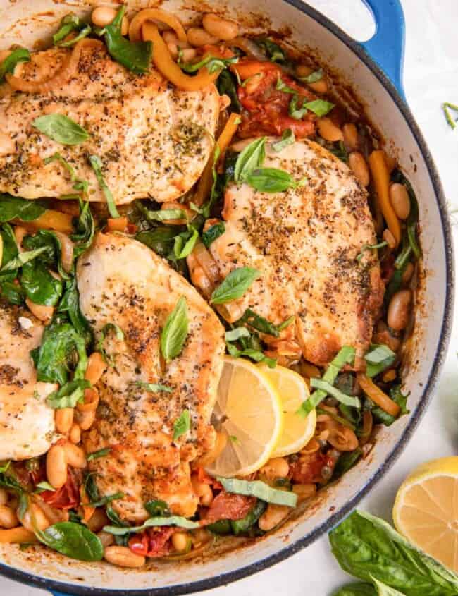 overhead partial close-up view of italian chicken skillet in a blue cast iron pan.