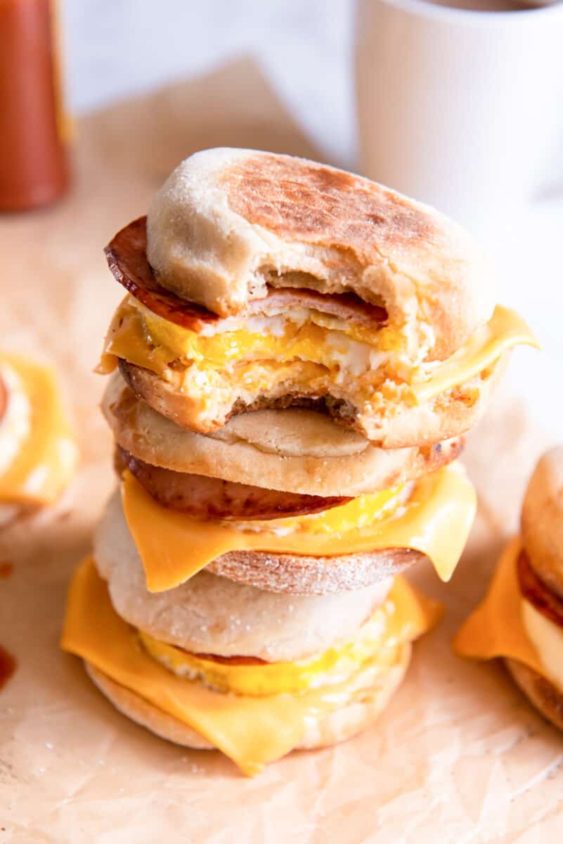 a bitten egg mcmuffin on a stack of egg mcmuffins.