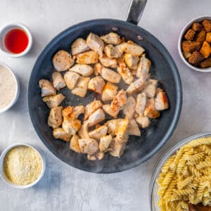 cooked cubed chicken in a frying pan.