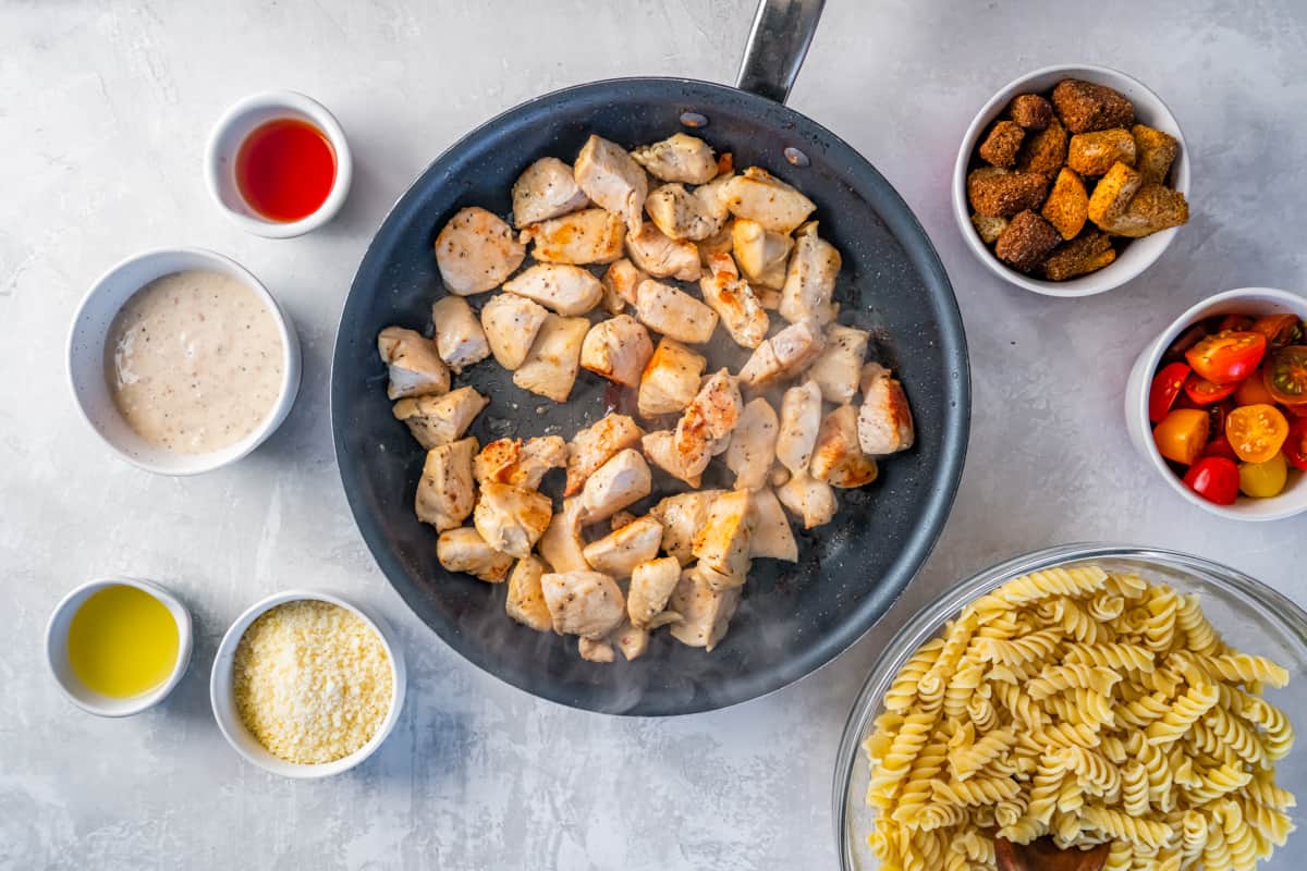 Cubes of cooked chicken in a skillet.