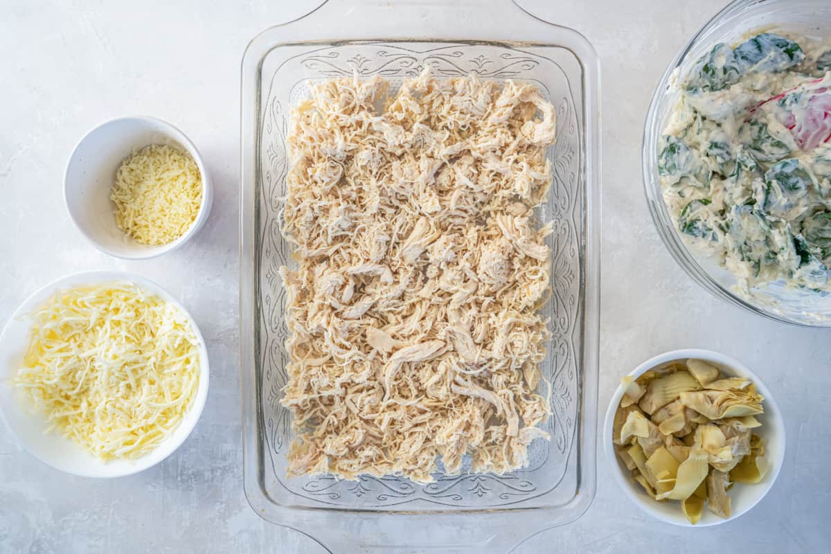 shredded chicken in a glass rectangular baking pan.