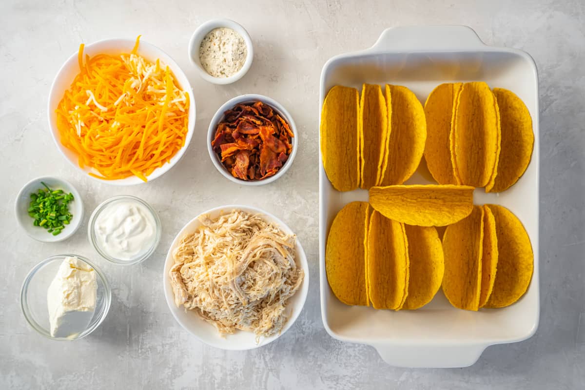 baked taco shells standing upright in a white rectangular baking pan.