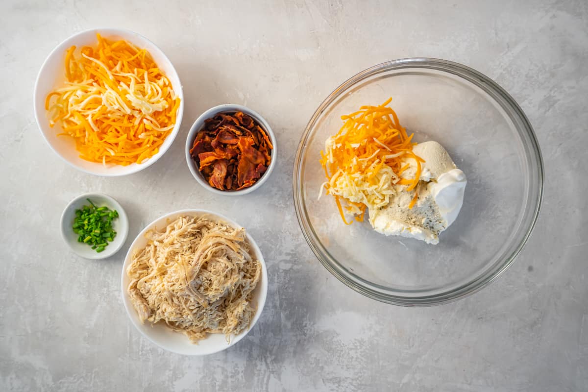 sour cream, ranch, and cheese in a glass bowl.