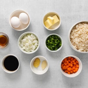 overhead view of ingredients for egg fried rice in individual bowls.