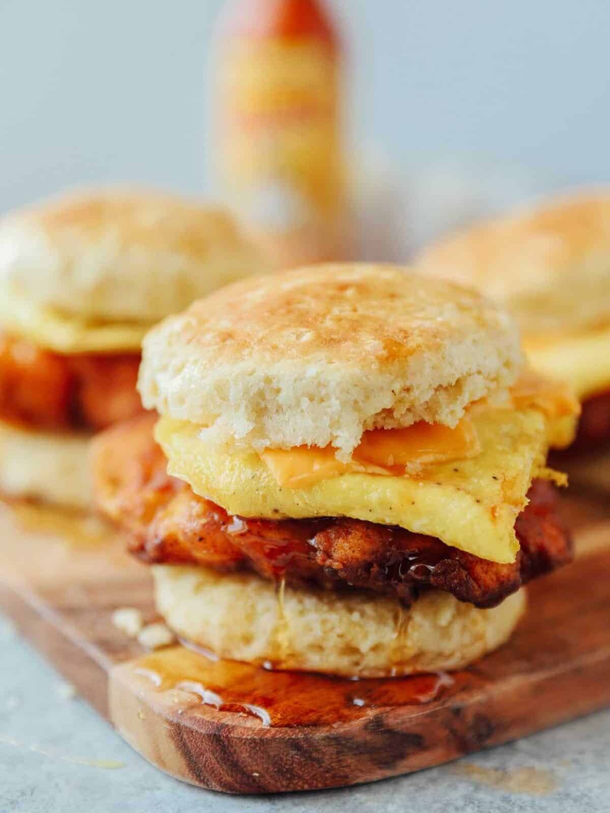 side view of a breakfast sandwich with biscuits, eggs, cheese, and chicken