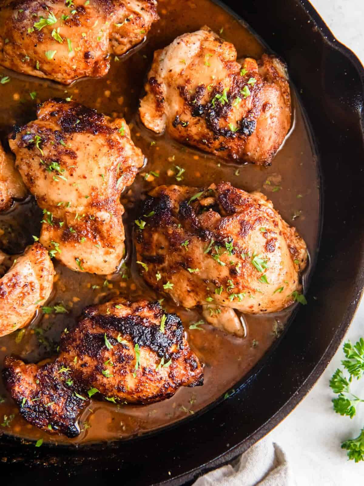 close up on a skillet full of cajun butter chicken thighs