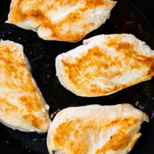 seared chicken breasts in a skillet.