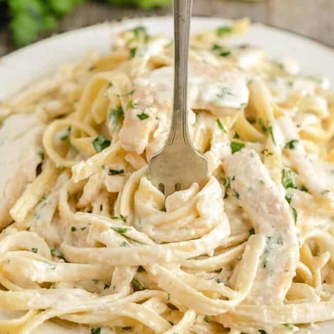 pasta tossed in alfredo sauce with chicken in a bowl