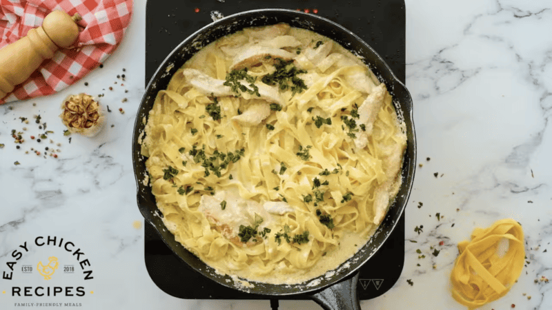 Delicious chicken fettuccine in a skillet with parmesan cheese, perfect for a cozy night in.