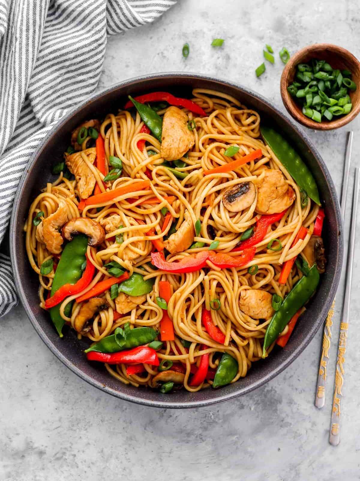 overhead view of chicken lo mein in a skillet