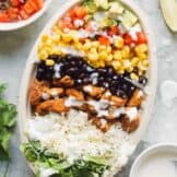 layered chicken burrito bowl next to ingredients