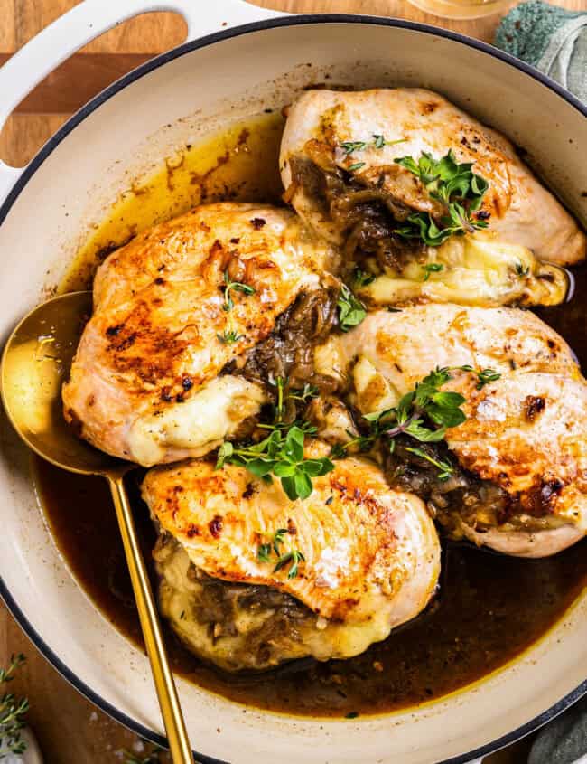 french onion stuffed chicken in a pot with a spoon.