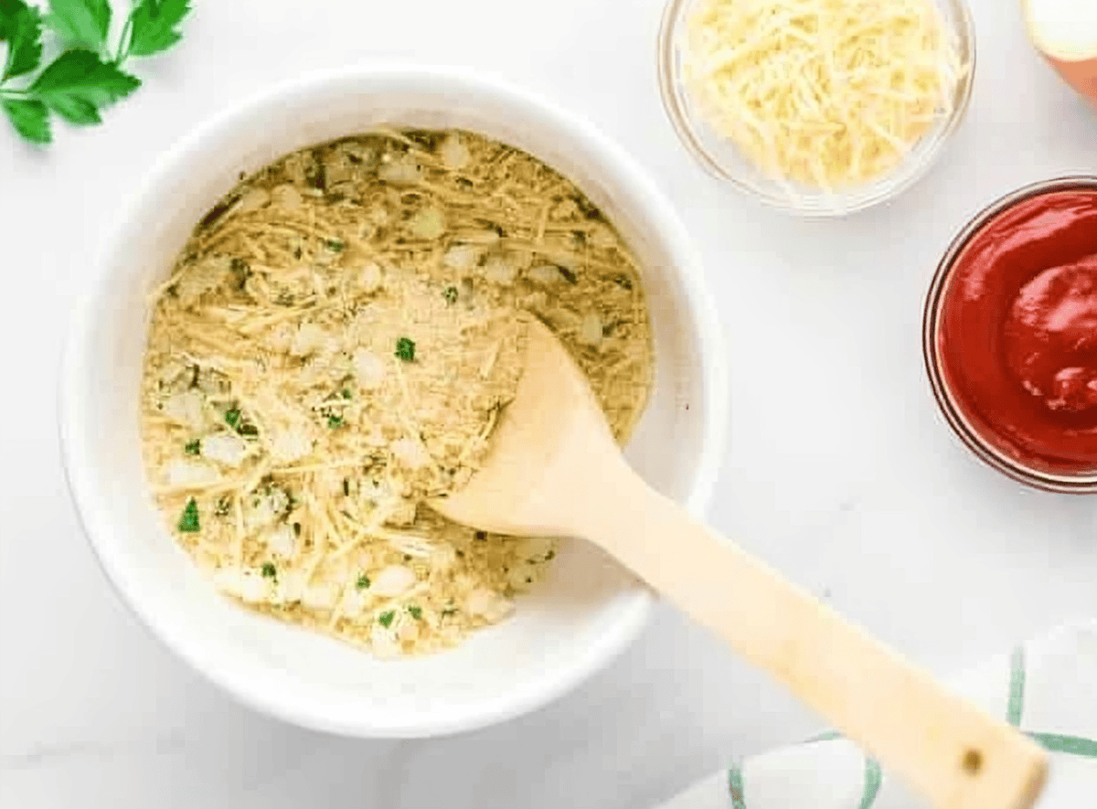 seasoned breadcrumbs in a white bowl with a wooden spoon.