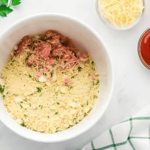 ground chicken and seasoned breadcrumbs in a white bowl.