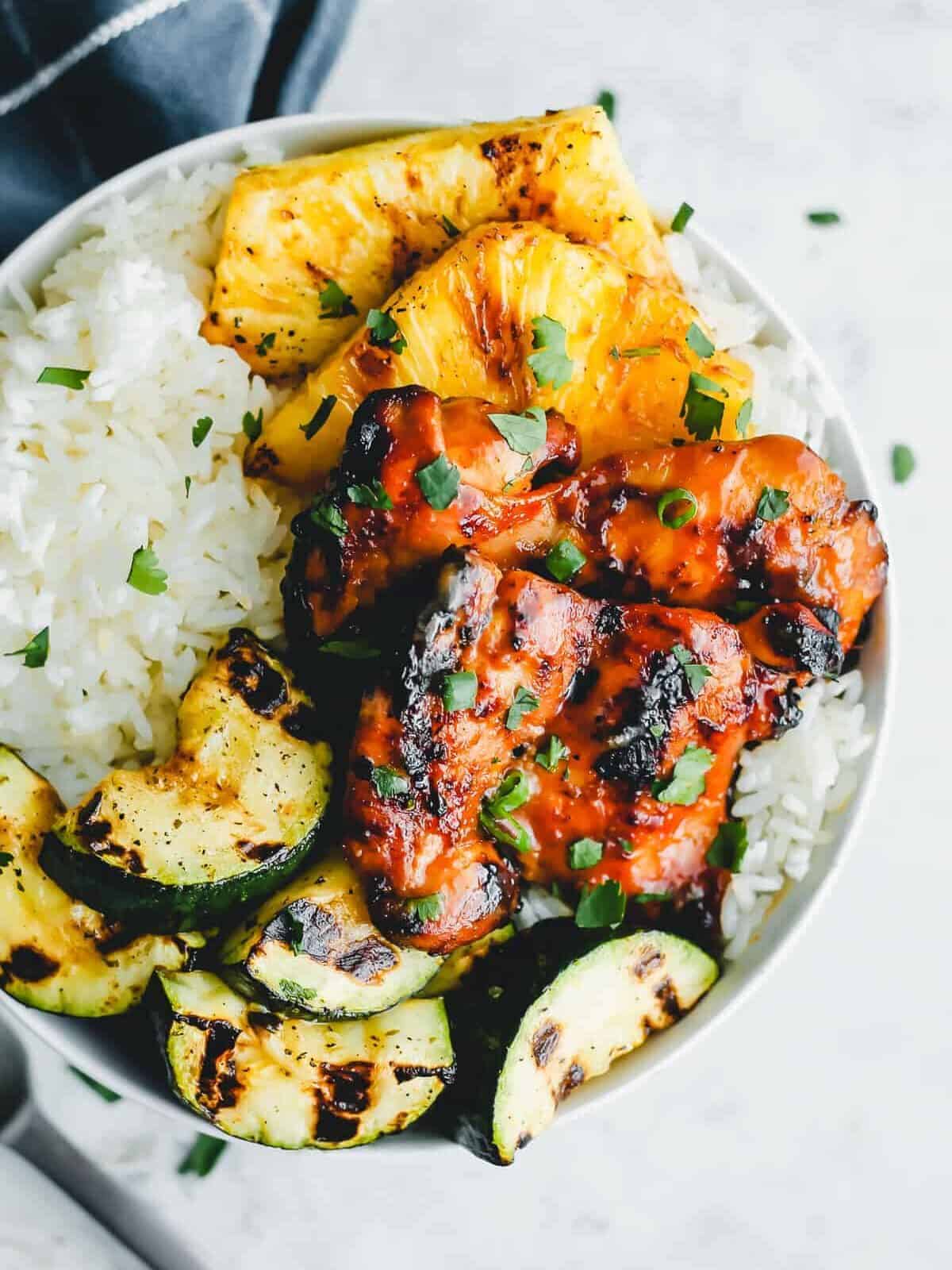 grilled huli huli chicken with pineapple and veggies on plate of rice