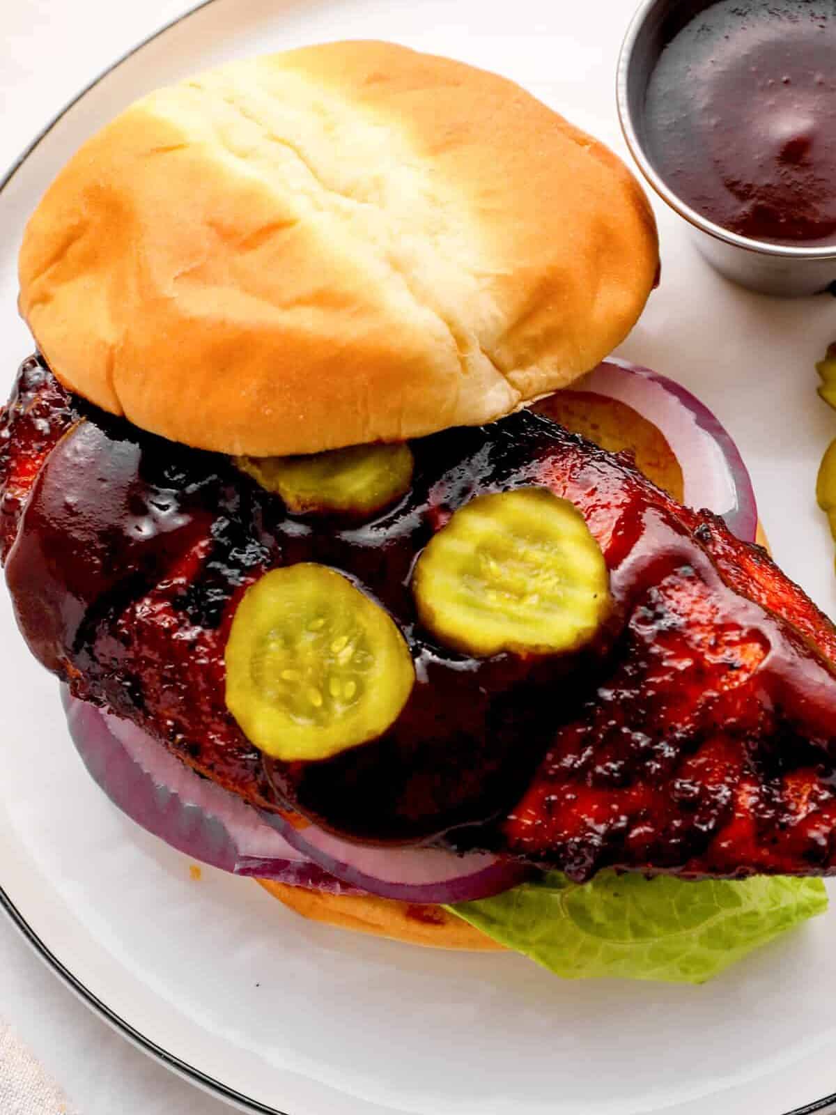 close up on bbq chicken sandwich with pickles