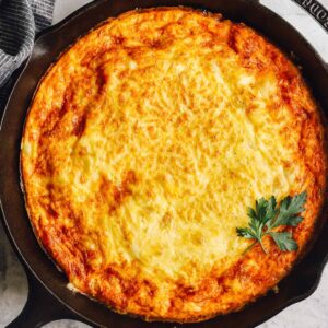 overhead view of a ham and cheese frittata in a cast iron pan.