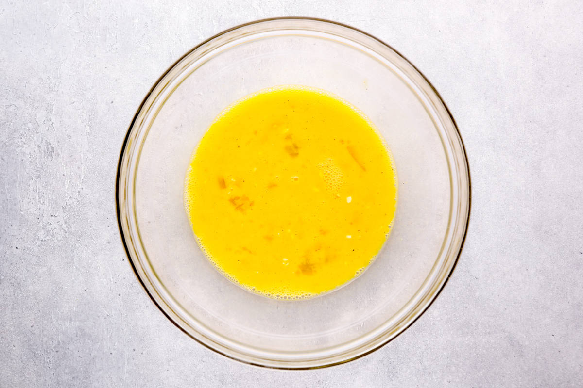 raw whisked eggs in a glass bowl.