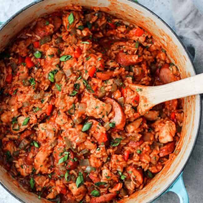 chicken and rice in a pot with a wooden spoon.