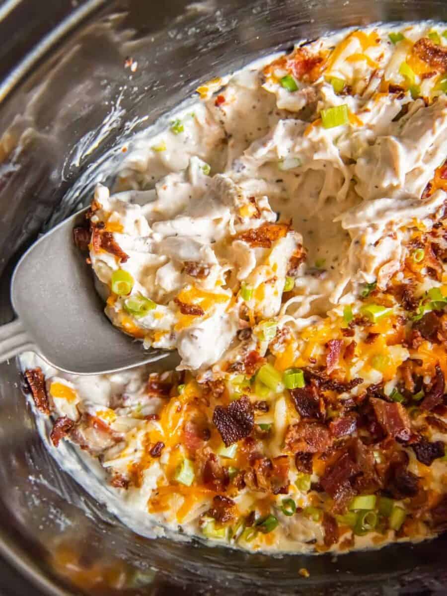Creamy crack chicken with cheese, bacon, and ranch, in a Crockpot.