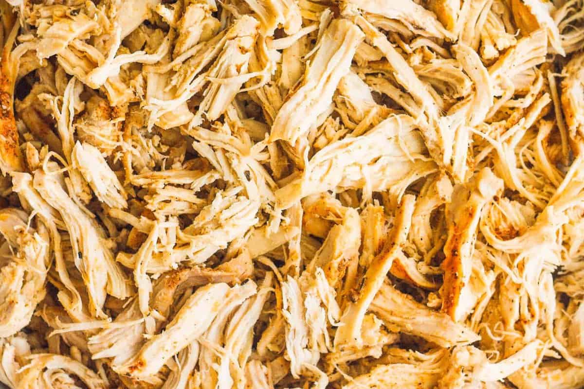 Up close image of crockpot shredded chicken breasts.