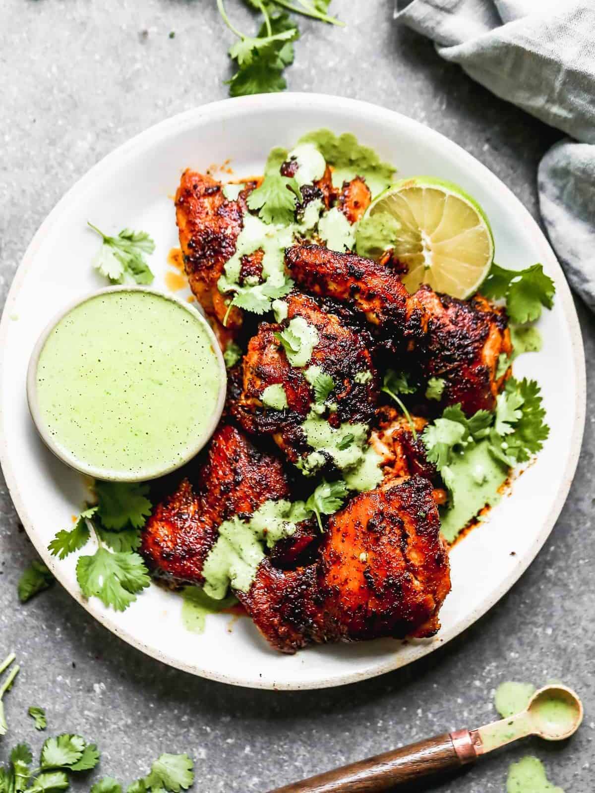 peruvian chicken with green sauce on white plate