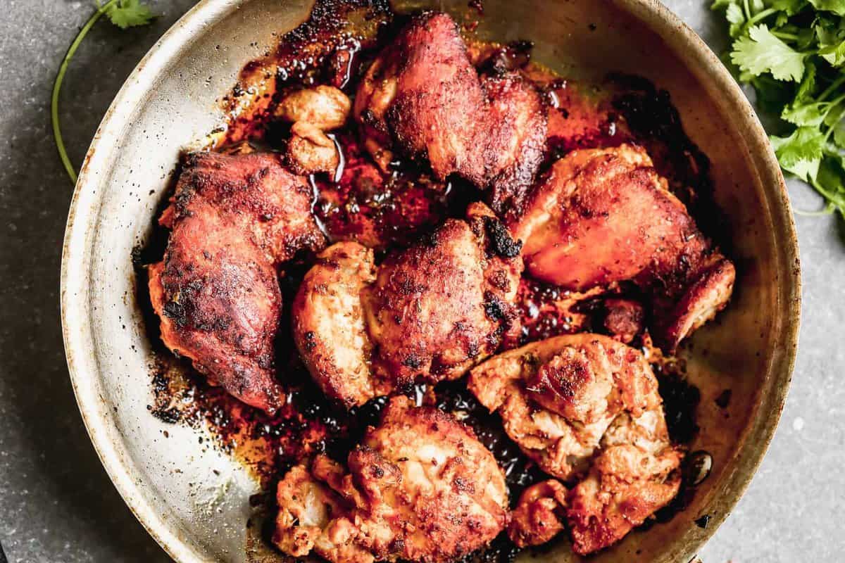 cooking spiced chicken thighs in skillet