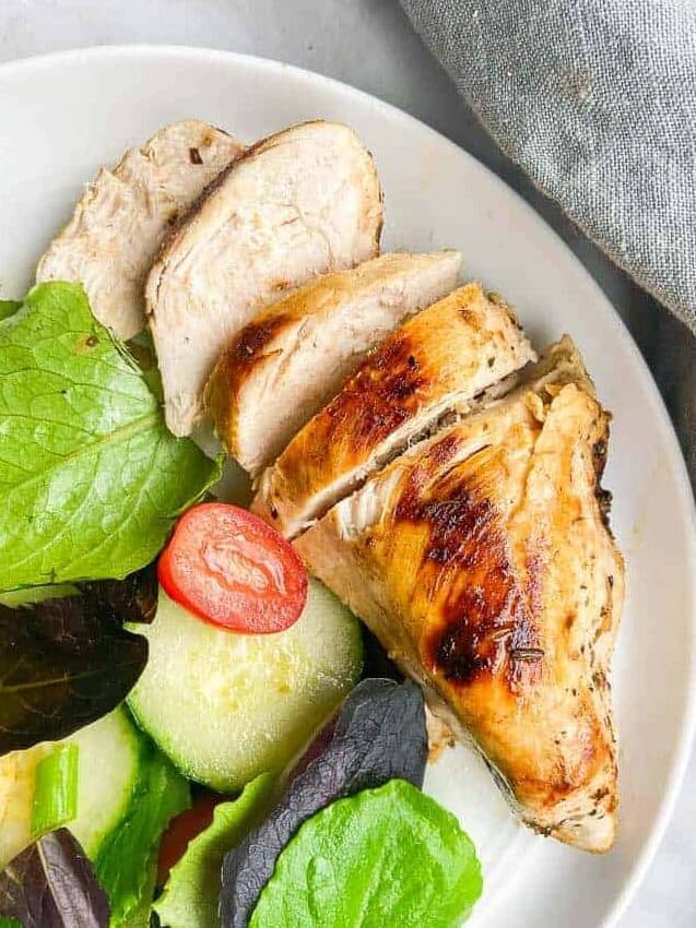sliced chicken breast on plate with salad