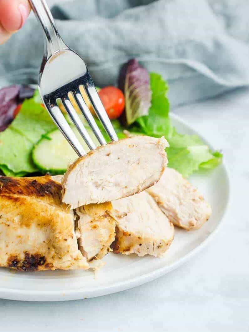 using a fork to pick up a slice of chicken