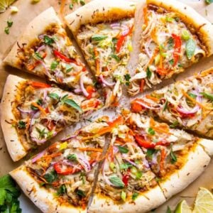 overhead view of a thai chicken pizza cut into slices