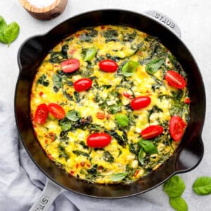 overhead view of a vegetable frittata in a cast iron pan.