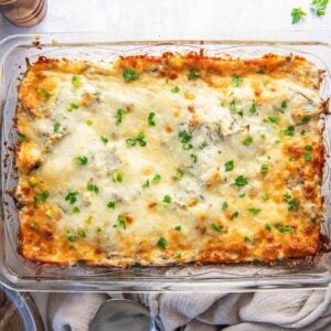 overhead view of spinach artichoke chicken casserole in a rectangular glass baking pan.