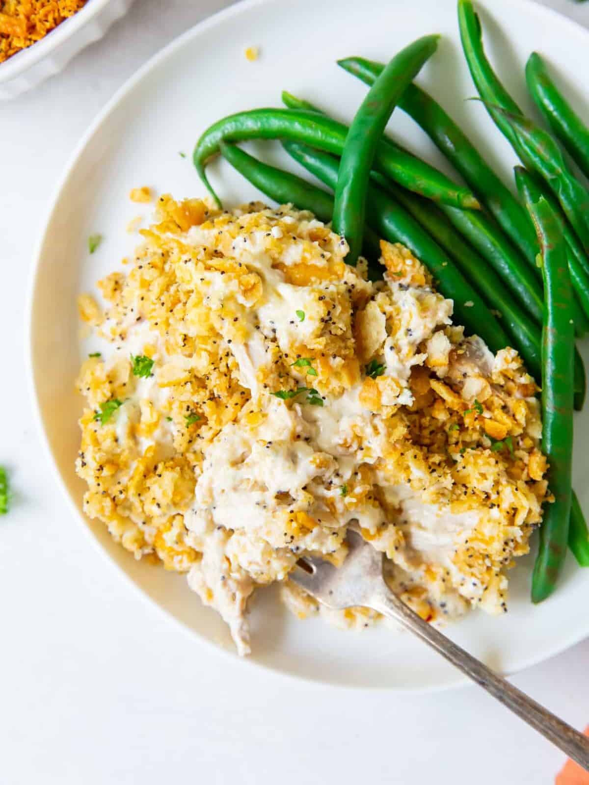 poppyseed chicken casserole on a plate with green beans