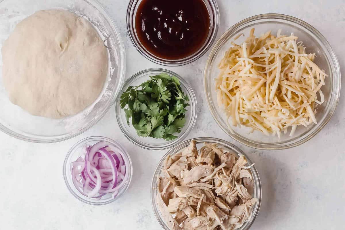 bbq chicken pizza ingredients and toppings arranged in bowls