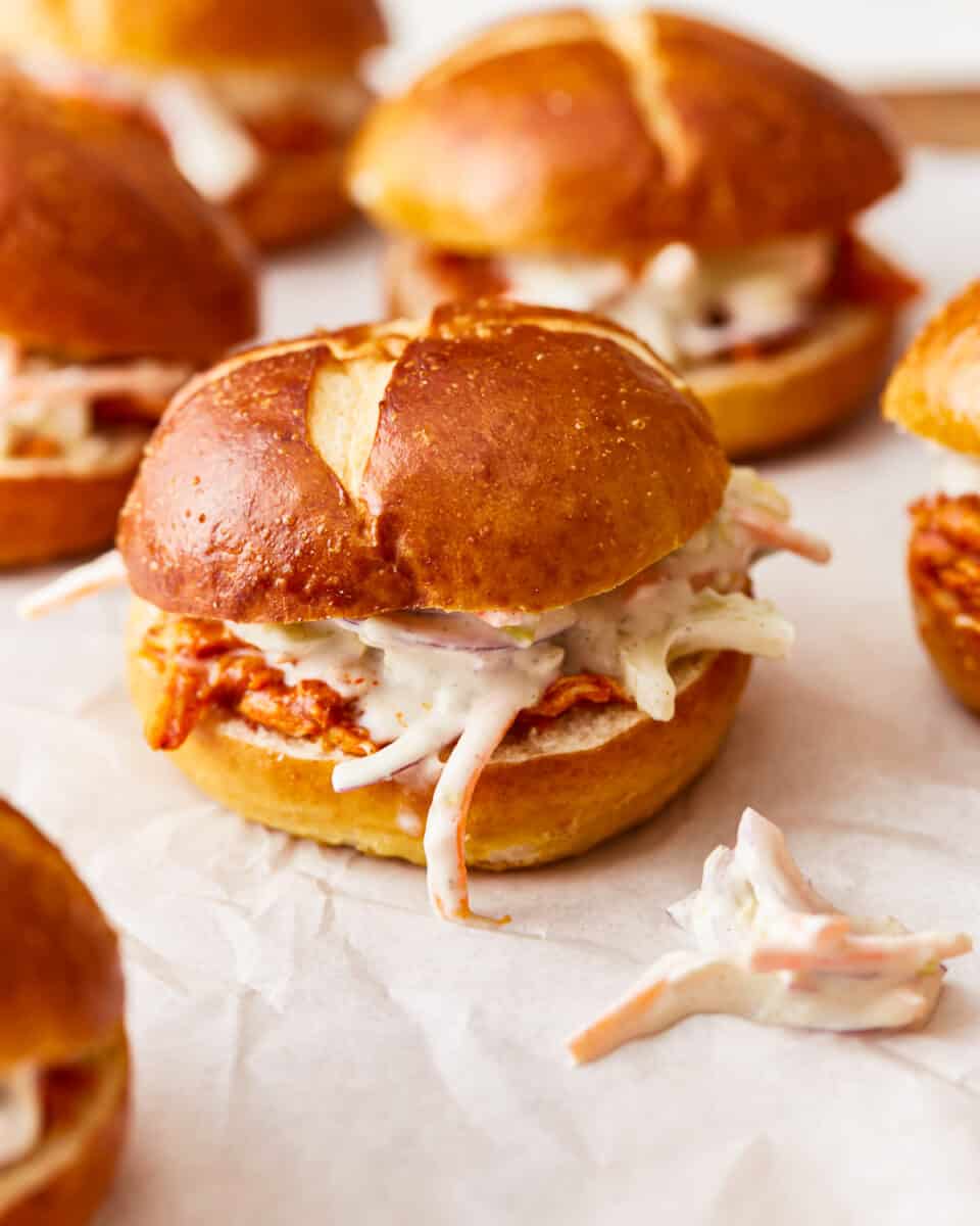 A group of sandwiches with coleslaw on them.