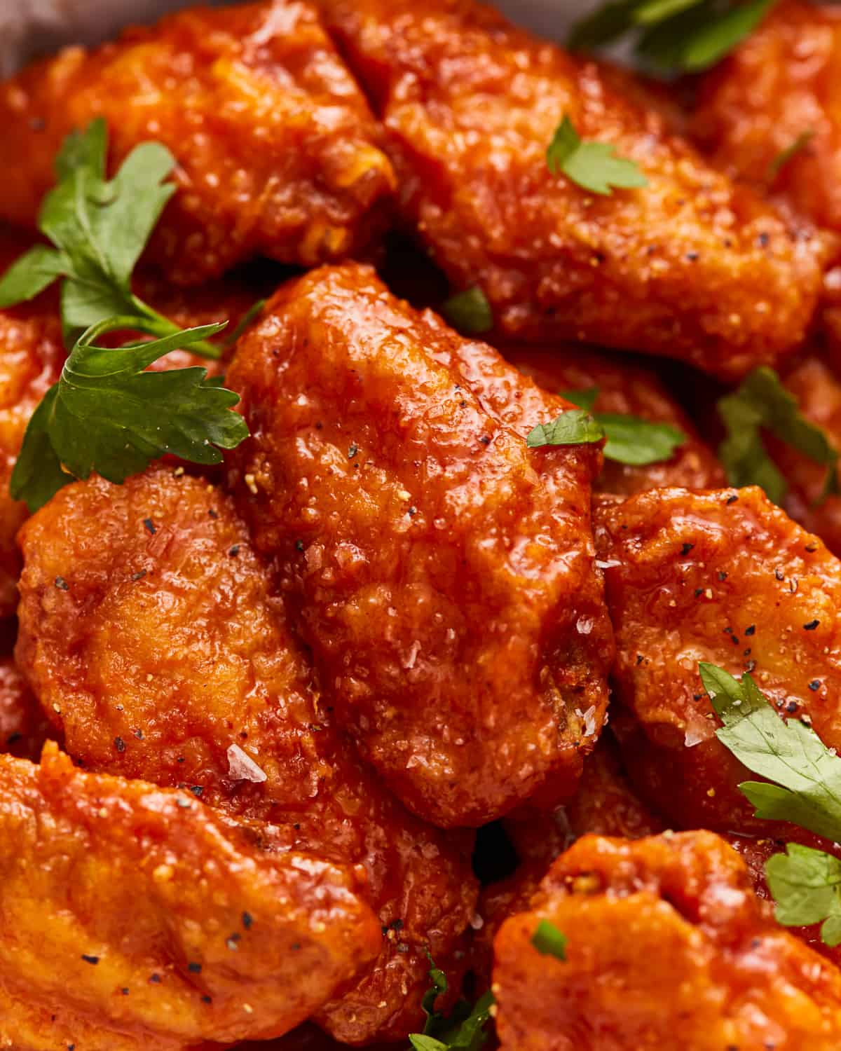 Bbq chicken wings in a bowl with parsley.