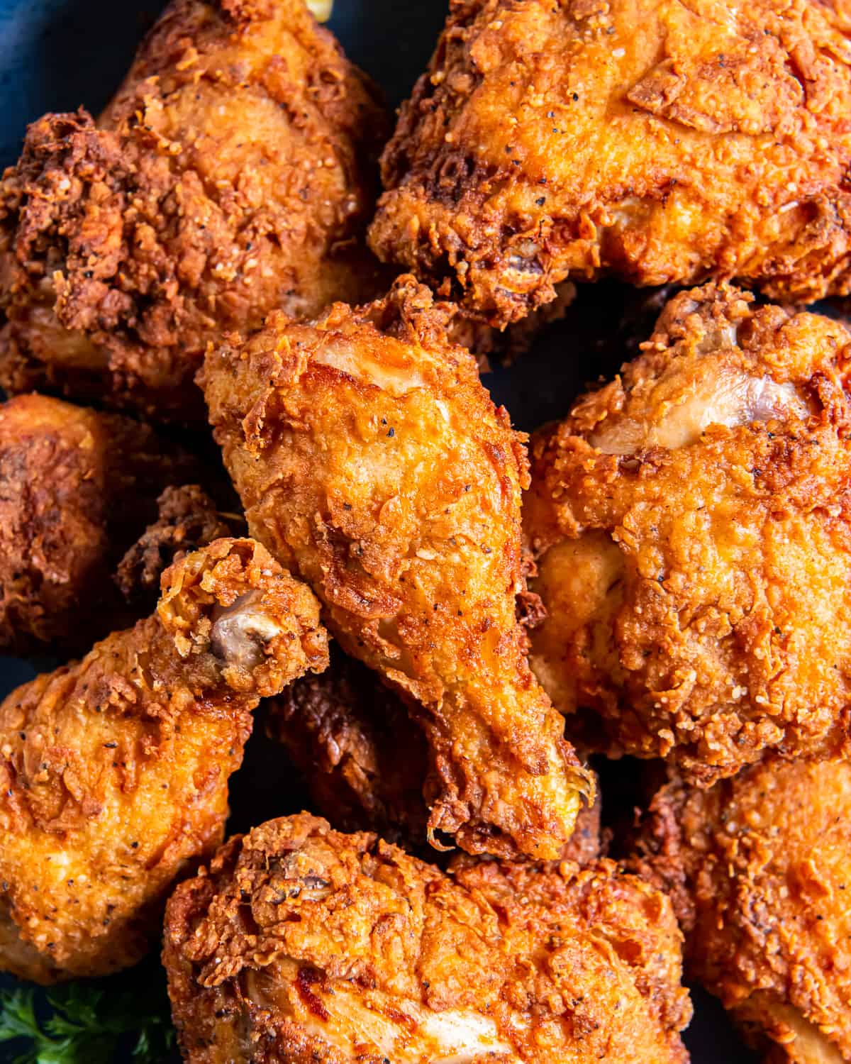 close up in a pile of crispy buttermilk fried chicken.