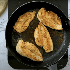 seared chicken breasts in a cast iron skillet.