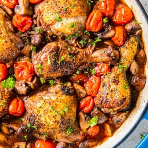 A pan with chicken and mushrooms in it.
