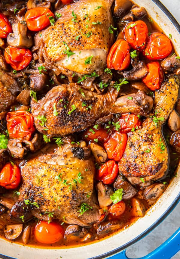 A pan with chicken and mushrooms in it.