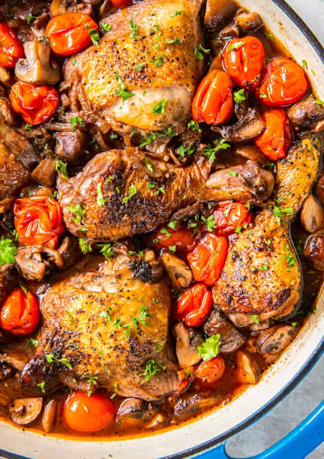 A pan with chicken and mushrooms in it.