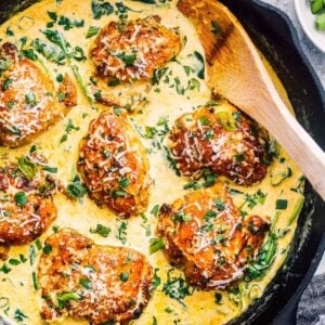 wooden spoon in cast iron skillet with chicken florentine