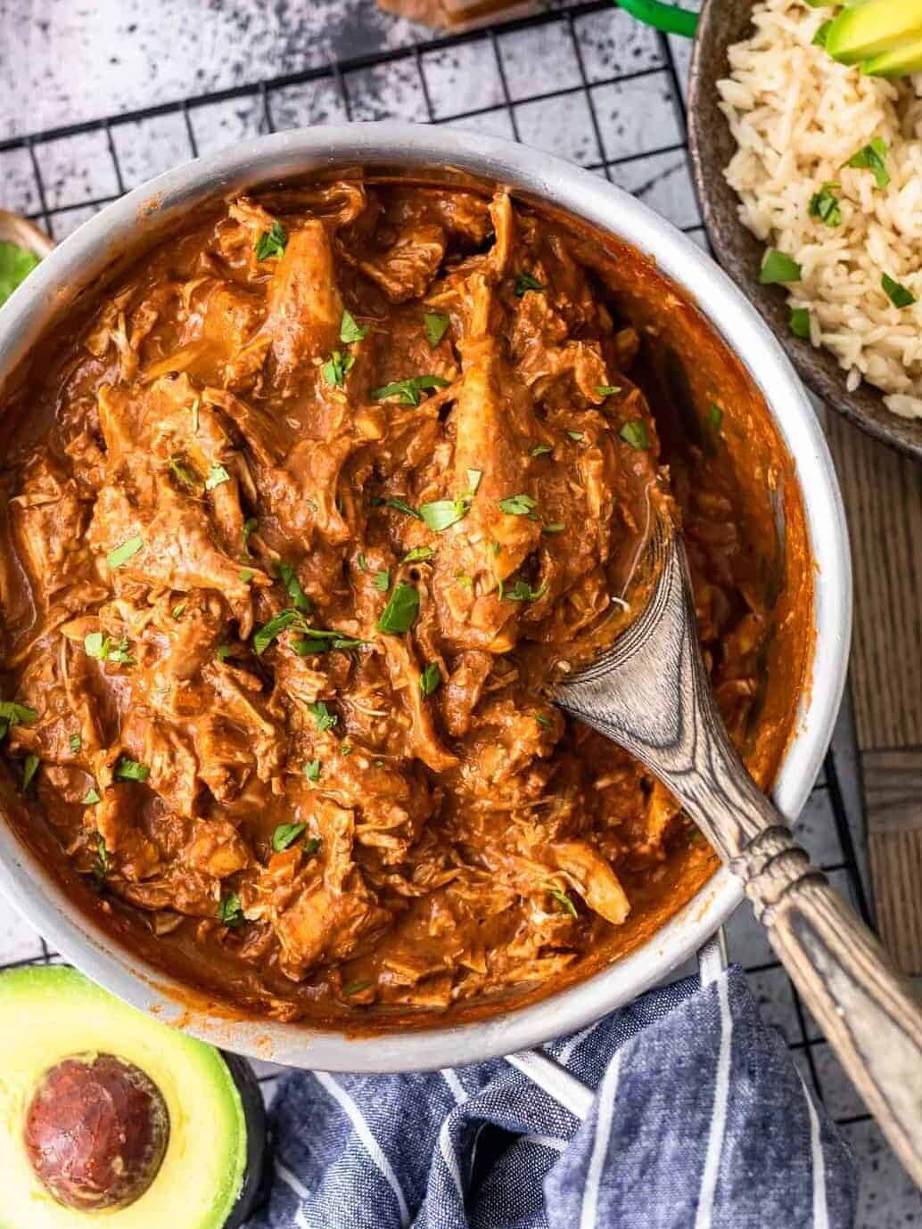 easy chicken mole in a saucepan with rice and avocado