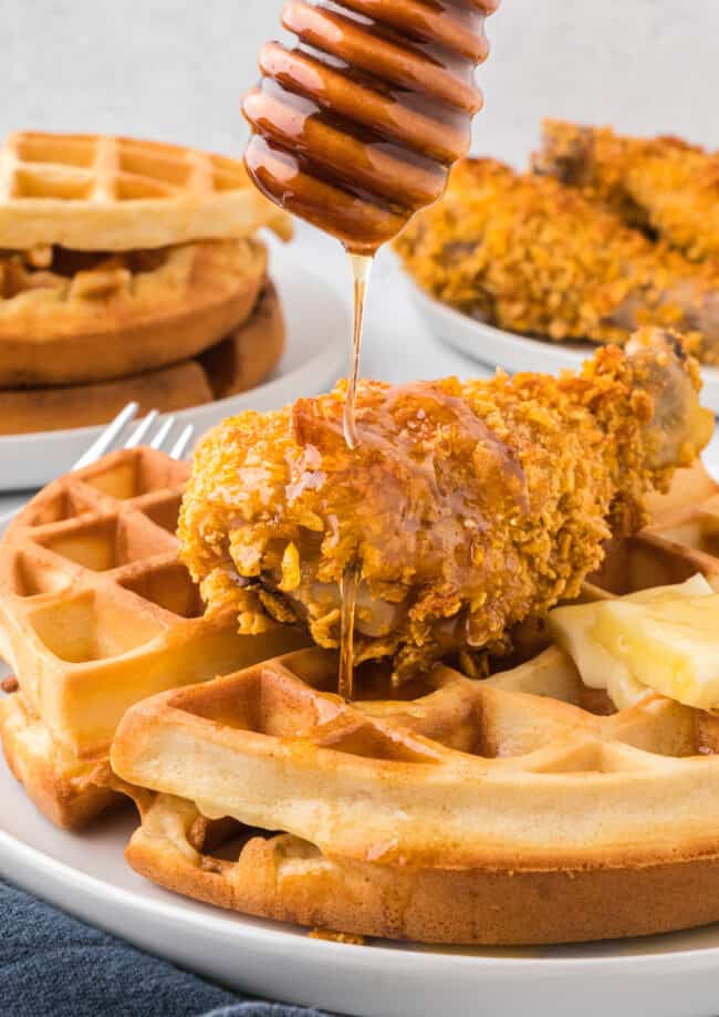 Waffles with chicken and honey drizzled on them.